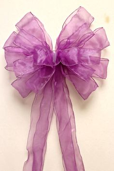 a purple bow on a white surface with no one in the photo looking at it