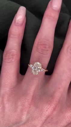 a woman's hand with an engagement ring on her left and two diamonds on the right