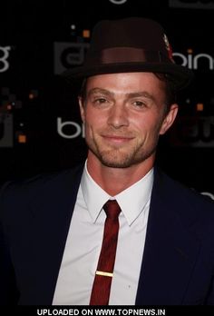 a man in a suit and tie wearing a hat