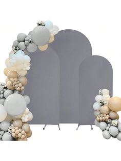 an arch decorated with balloons and flowers on top of a white backdrop for a wedding ceremony