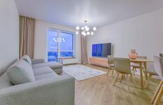 a living room filled with furniture and a flat screen tv sitting on top of a wooden floor