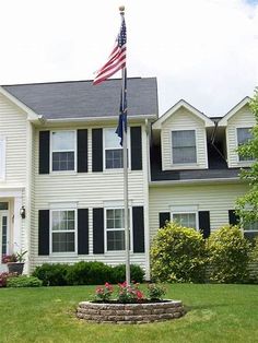 a large white house with an american flag in the front yard