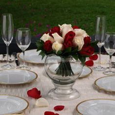 the table is set with white and red roses