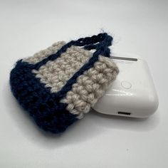 a crocheted cell phone case sitting on top of a computer mouse