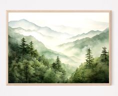 a painting of mountains and trees in the foggy mist with white frame on wall