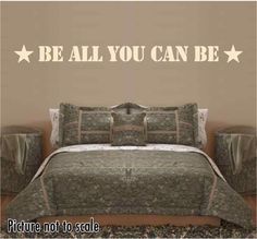 there is a bed with pillows and blankets on it in front of a wall that says be all you can be