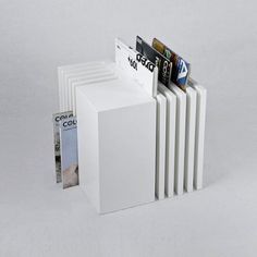 four white books are stacked on top of each other in the shape of a book holder