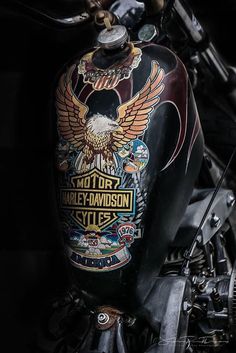 the back end of a motorcycle with an eagle and harley davidson emblem on it's tank