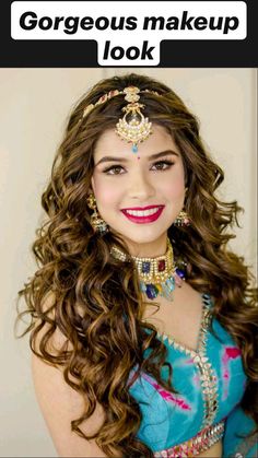 a woman with long brown hair wearing a blue dress and headpiece, smiling at the camera