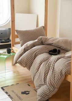 a bedroom with a bed, desk and computer on the floor in front of it