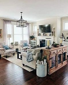 a living room filled with furniture and a flat screen tv mounted on the wall above a fireplace