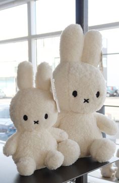 two white stuffed animals sitting on top of a table