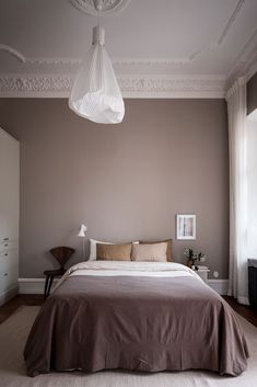 a bedroom with a bed, nightstands and lamp in the corner on the wall