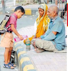 an older man and two young children are sitting on the curb, one is pouring water into a cup