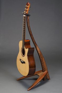 a wooden guitar stand holding an acoustic instrument