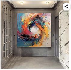 an abstract painting hangs on the wall next to a large window in a room with marble walls