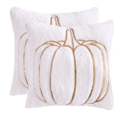 two white pillows with gold pumpkins on them