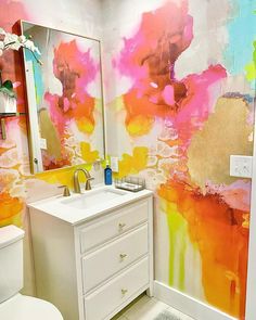 a bathroom decorated in bright colors and white fixtures