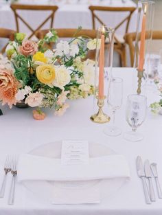 the table is set with flowers, candles and silverware for an elegant wedding reception