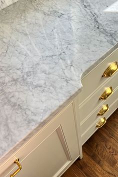 a white marble counter top with gold handles