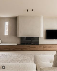 a modern living room with white furniture and a flat screen tv mounted on the wall