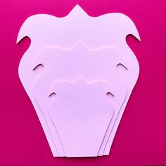 white paper cut out into shapes on a pink background