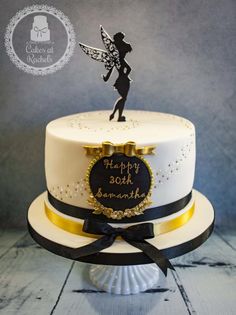 a birthday cake with a fairy on top that reads happy 30th sonneth and has a black ribbon around the edge