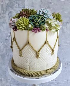 a white cake with succulents on top