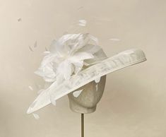 With a burst of white feathers and matching trim on this wide brimmed off white hat make it perfect for Mother of the Bride, ladies day or finishing touch to your special occasion outfit.  Perfect for Mother of the Bride any wedding outfit and is equally suitable for a finishing touch to your ladies day or garden party outfit.  The piece is 43cm across  Each piece is handmade by me for you, using the highest quality materials which takes about 5 days. If you have a specific date you need the headpiece please get in touch and I will ensure you receive in good time. If you would like the piece to be made to match your outfit, or adapted please contact me (a swatch can be sent or matched to your required colour) Please check policies and FAQ for any further information on how to wear your hea Classic White Top Hat For Kentucky Derby, Classic White Fascinator, Classic White Mini Hat With Curved Brim, White Classic Mini Hat With Curved Brim, Classic White Hat With High Crown, Classic White High Crown Hat, White Party Hat With Feather Trim, White Feather Trim Party Hat, Classic White Hat For Royal Ascot