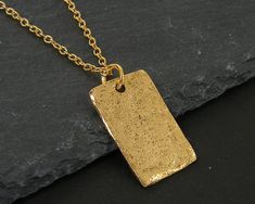 Simple gold rectangle necklace featuring a textured gold pendant. The edges are not entirely smooth and they have a distressed texture that make them look like relics from long ago. Charms are manufactured in the US and are made of pewter that meet CPSIA standards. Charms are 3/4 inches tall and 1/2 inches wide (1.9 x 1.3 cm). Your choice of necklace length - 18 or 20 inches. Thank you for stopping by! Find more handmade necklaces here - https://www.etsy.com/shop/BeautifulByCharlene?section_id=1 Gold Hammered Rectangular Jewelry, Hammered Gold Rectangular Jewelry, Gold Rectangular Brass Necklace, Rectangular Gold Brass Necklace, Rectangle Necklace, Distressed Texture, Minimalist Contemporary, Newport News, Modern Necklaces