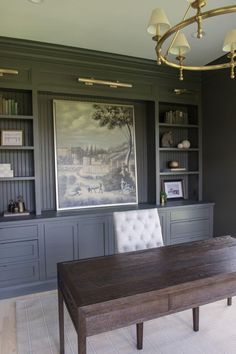 a dining room with built in bookcases and a painting on the wall