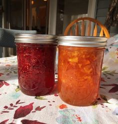 two jars filled with liquid sitting on top of a table