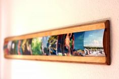 a wooden frame hanging on the wall with pictures in it's center and bottom