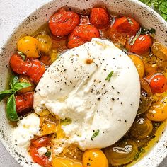 a bowl filled with lots of different types of food on top of a white table