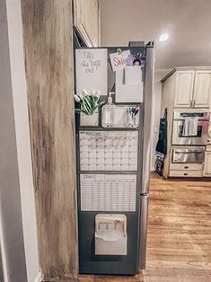 a refrigerator with magnets and papers on it in a kitchen next to a wooden floor