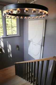 a light fixture hanging from the side of a stair case next to a window in a house