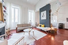 a living room filled with furniture and a spiral staircase in the wall next to a fire place