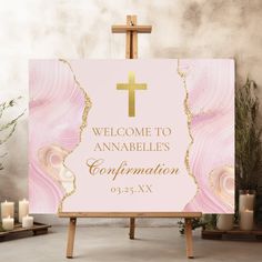 a pink and gold welcome sign with a cross