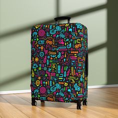 a colorful suitcase sitting on top of a hard wood floor next to a green wall