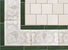 white and green tiles are arranged on the wall