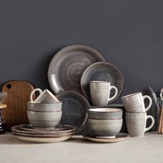 a table topped with plates and cups next to utensils on top of a counter