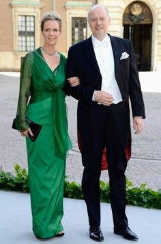 an older man and woman dressed in formal wear standing next to each other on a sidewalk