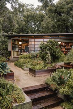 an outdoor garden area with steps leading up to the front door and bookshelves