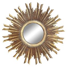 a gold sunburst mirror on a white wall