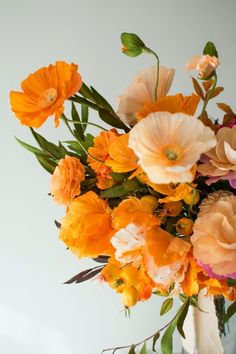 an arrangement of orange and pink flowers in a vase