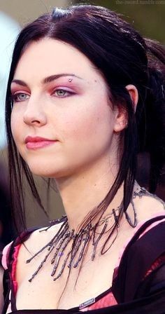 a close up of a woman with very large breast and necklaces on her neck