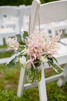 a bouquet of flowers sitting on top of a white chair next to an empty seat