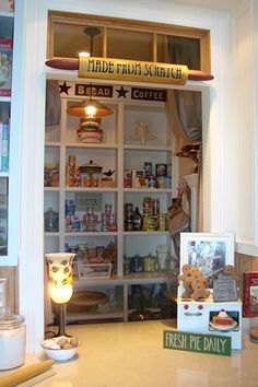 the inside of a store filled with lots of food and drink items on shelves next to a window