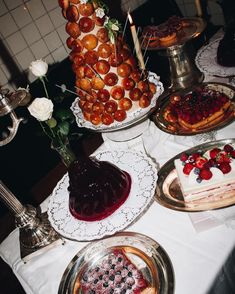 a table topped with cakes and desserts covered in frosting on top of plates