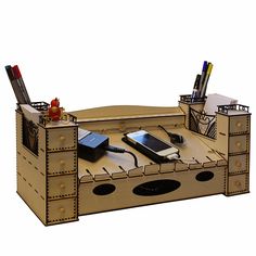 a wooden desk with cell phones, pens and pencils in the drawer on it